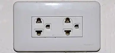 An earthed Thai socket that appears to comply with figure 4 of TIS 166-2549. Although it may accept NEMA plugs, the Thai voltage is 220&nbsp;V and thus is electrically incompatible with devices designed only for 110 V.