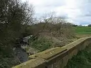 The River Wiske flowing under the old A167 bridge..mw-parser-output .geo-default,.mw-parser-output .geo-dms,.mw-parser-output .geo-dec{display:inline}.mw-parser-output .geo-nondefault,.mw-parser-output .geo-multi-punct{display:none}.mw-parser-output .longitude,.mw-parser-output .latitude{white-space:nowrap}54°25′36″N 1°27′54″W﻿ / ﻿54.426645°N 1.465125°W﻿ / 54.426645; -1.465125
