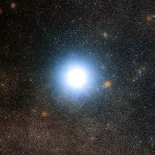 Large fuzzy white disk against a background of stars