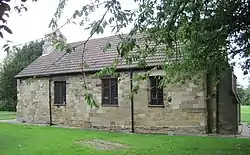 Image of old church building with a tree obscuring the right end