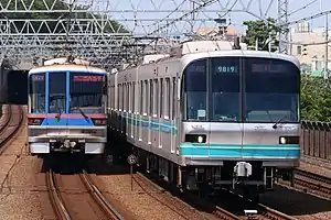 Top: The logos of the Tokyo Metro and Toei Subway Bottom: Toei 6300 series (left) and Tokyo Metro 9000 series (right) trains at Tamagawa Station