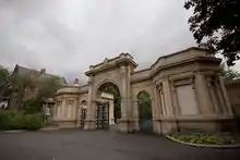 Arched gate with a small lodge to right and left