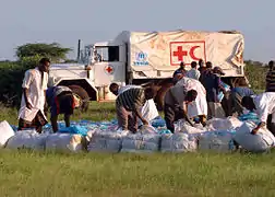 Workers from the UNHCR, and CARE International gather bundles of shelters and mosquito nets in Kenya