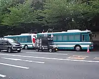 An uyoku gaisensha passing two Tokyo Metropolitan Police Department riot buses.
