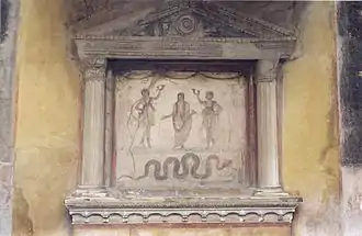 Ancestral genius (upper centre) flanked by Lares, with serpent below. Lararium, House of the Vettii Pompeii