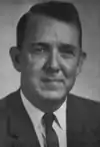 A photographic portrait of a man wearing a suit