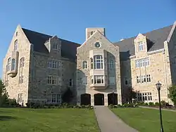 A 4-story stone building, with an asphalt walkway leading to a large entrance area