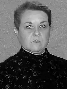 Black and white photo of a woman wearing a floral dress.