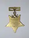 Back side of Pelham's medal with engraved text