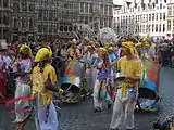 Colourfully-dressed participants playing musical instruments on the Grand-Place