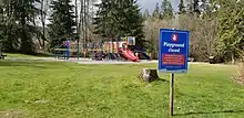 Playground in Port Moody, closed off with caution tape. A sign indicates the playground is closed.