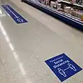 Social distancing floor signs in an Irish supermarket in August 2020.