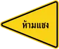 This no-overtaking zone sign is influenced by the U.S. but is pointing to the left. You cannot overtake when this sign is present.