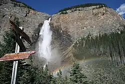 A waterfall with a sign in front of it